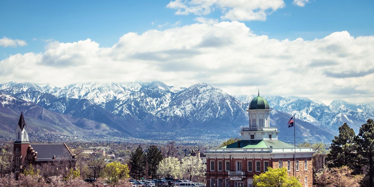 Snowy mountains behind a city with historic buildings.
