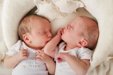 Two newborn babies sleeping peacefully side by side.