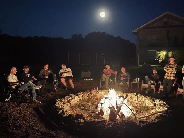 Mn's group gathering around a campfire at a Council Fire Thursday night meetup — real brotherhood an