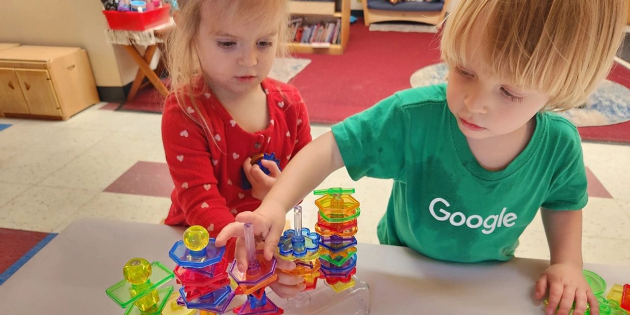 Photo of girl and boy playing together nicely in the classroom