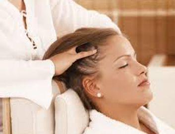 A woman enjoying a relaxing head massage in a spa setting.