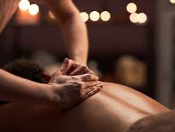 Person receiving a relaxing back massage in a dimly lit room.