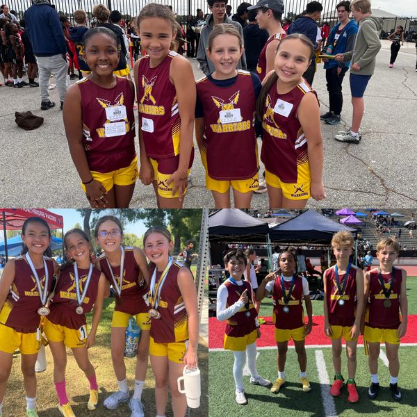 Young athletes in maroon and yellow Warriors uniforms smiling at a sports event.