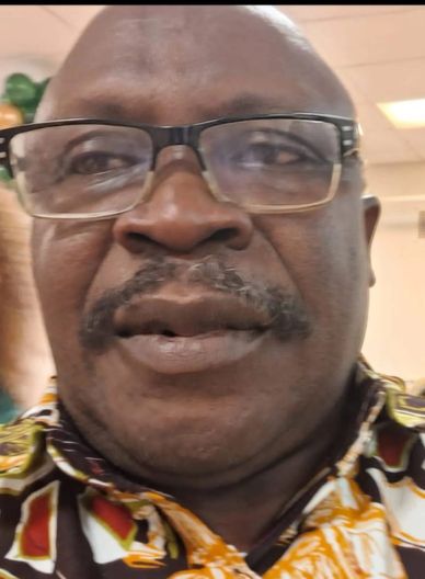 Close-up of a man wearing glasses and a colorful patterned shirt.