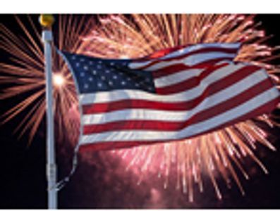 American flag waving with fireworks in background.