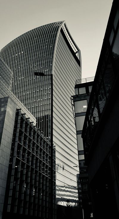 Tall modern skyscraper with curved top in black and white.