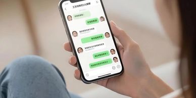 Person holding a phone showing a chat conversation in Chinese.
