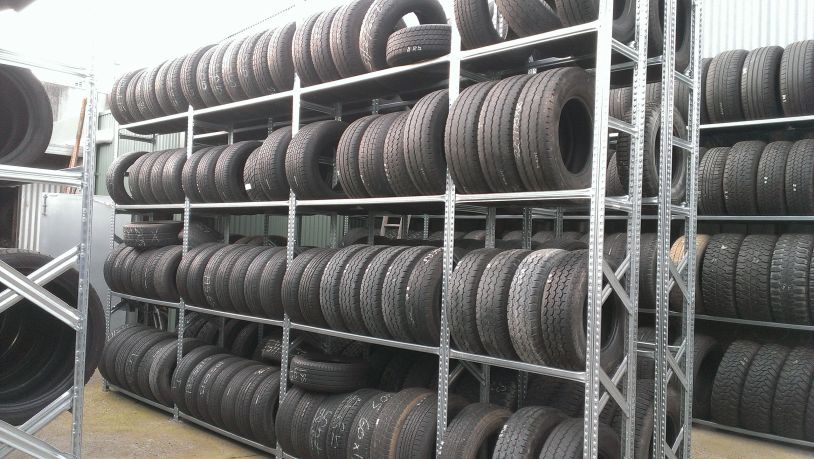 Shelves filled with stacked tires in a storage area.