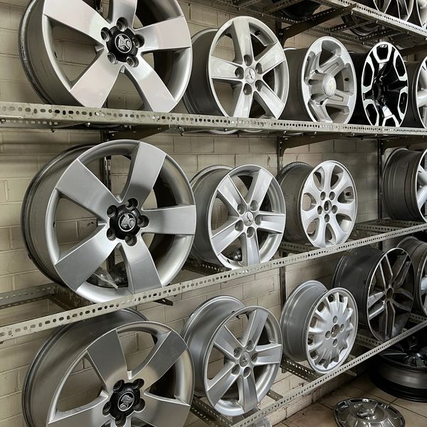 Shelves filled with various car rims in a showroom.