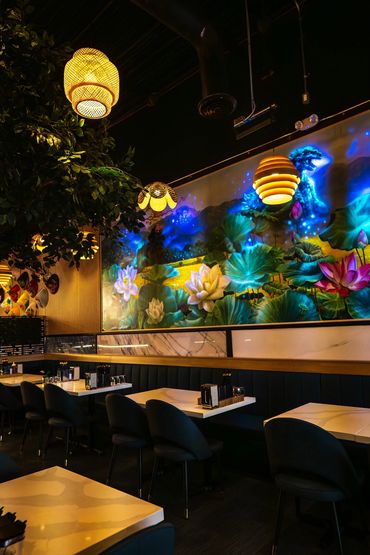 Cozy restaurant interior with floral mural and warm lighting.