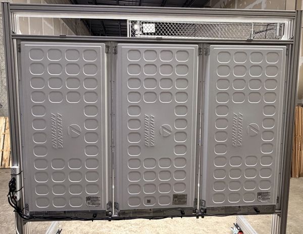 Three large industrial battery packs mounted on a metal frame.