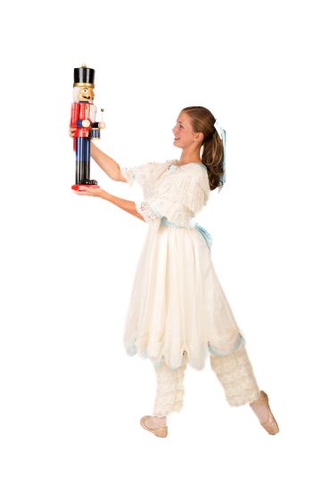 Ballet dancer in costume holding a large nutcracker figurine.