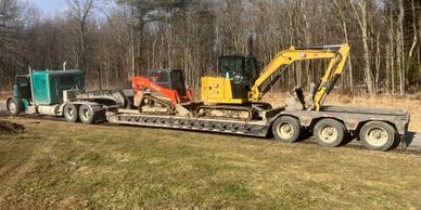 tractor trailer hauling a step deck trailer with a skid-steer and excavator on