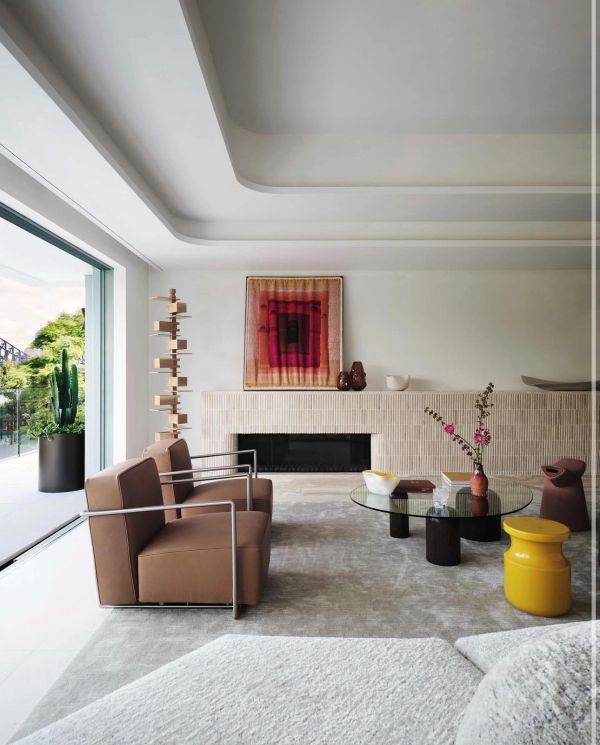 Modern living room with brown chairs and glass coffee table.