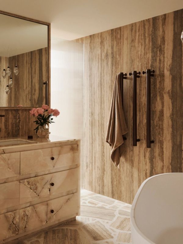 Elegant bathroom with marble vanity and towel hanging on wall.