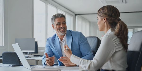 Senior professionals in discussion during a focused one-on-one meeting.