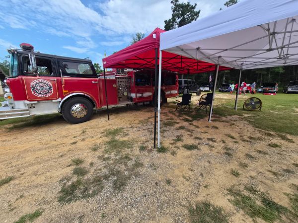 Fire truck parked under red and white tents.