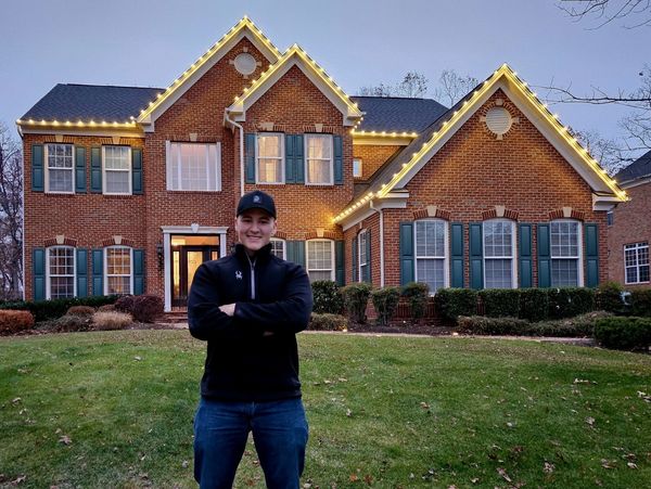 man standing in front of holiday lighting display