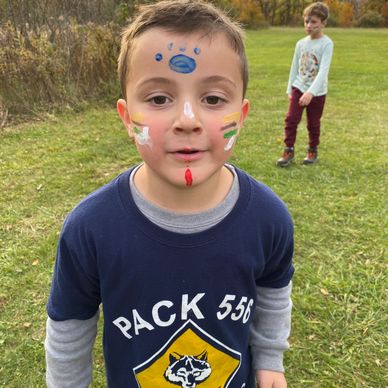Cub scout with face paint outside