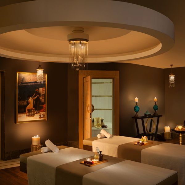 Serene spa room with massage tables, warm lighting, and candles.