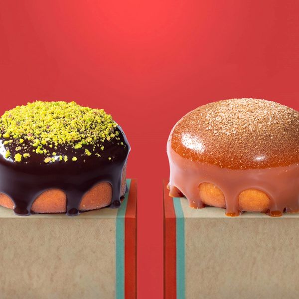 Two gourmet donuts with rich glazes and toppings on a red background.