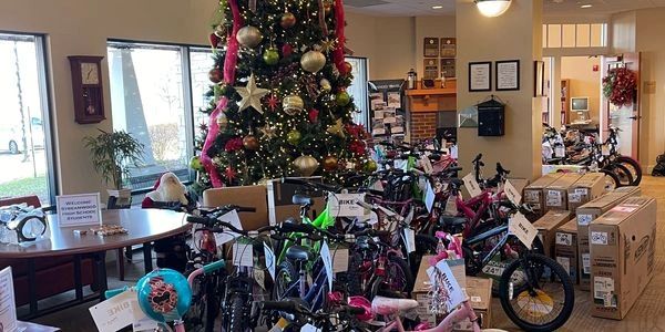 Dozens of new bicycles around a decorated Christmas tree