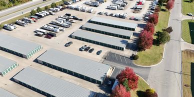 Aerial view of a storage facility with parked vehicles and storage units.