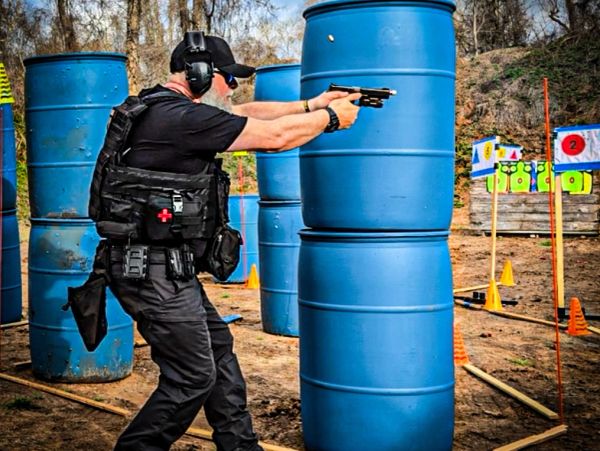 Man aiming a pistol at a shooting range.
