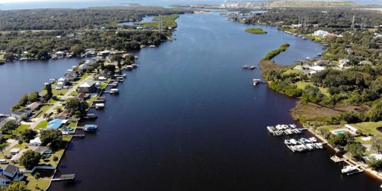 Aerial view of a river lined with houses and docks on both sides.