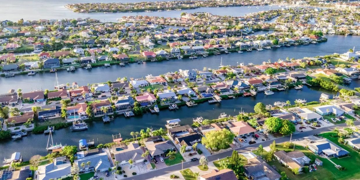 Aerial view of a waterfront residential neighborhood with canals and boats.