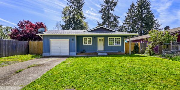 Blue single-story house with attached garage and green lawn.