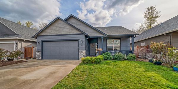 A modern single-story gray house with a well-kept front lawn and driveway.