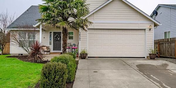 Single-story suburban house with a two-car garage and front yard.