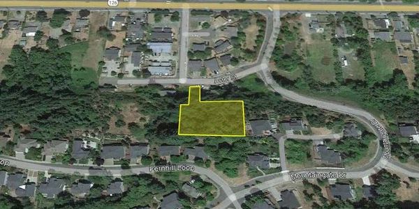 Aerial view of a residential area with a highlighted plot of land.