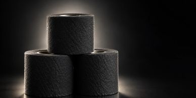 Three rolls of black toilet paper stacked.