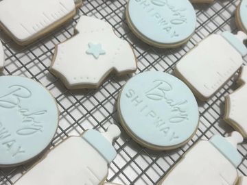 Baby-themed iced cookies on a cooling rack.