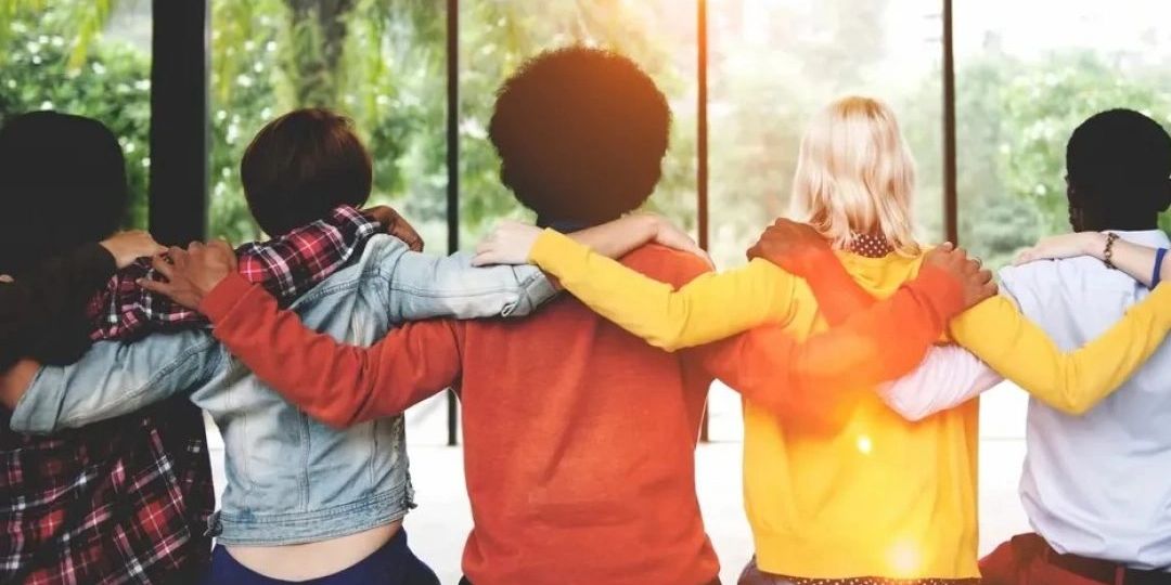 Group of diverse people linking arms in unity.
