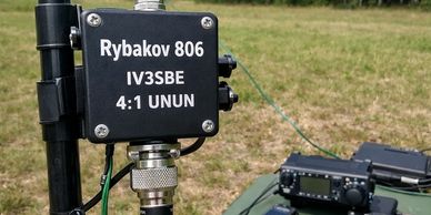 A radio antenna setup with a labeled device and radio equipment outdoors.