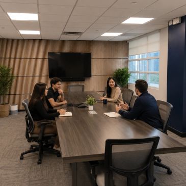 Four colleagues having a meeting in a modern conference room.