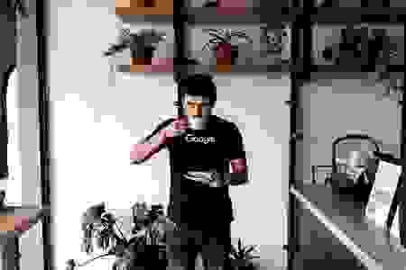 Man wearing Google t-shirt drinking coffee