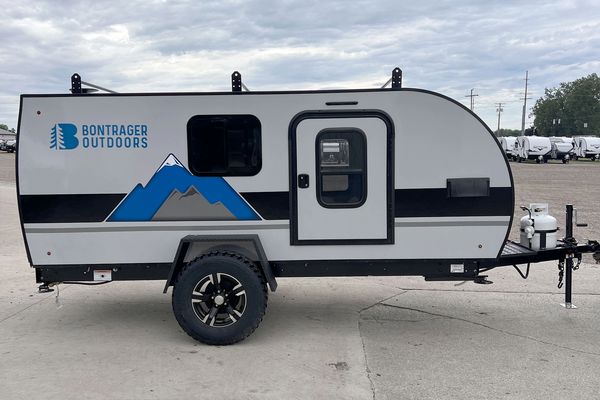 Compact Bontrager Outdoors travel trailer parked on concrete.