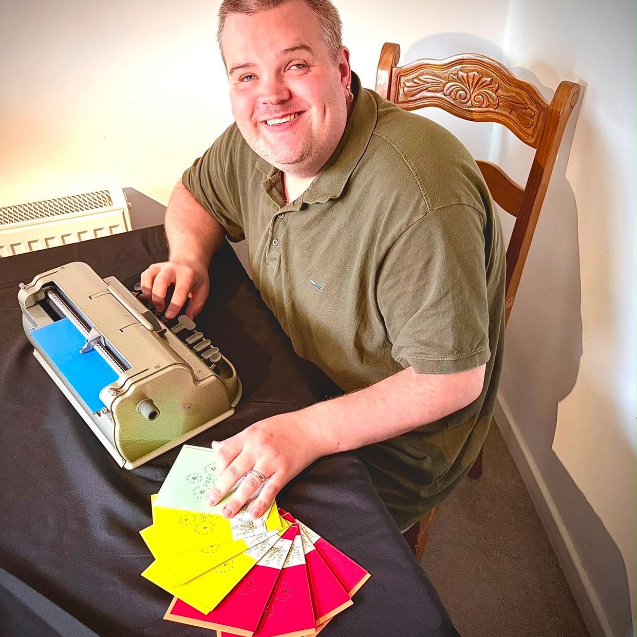 Vinny smiling whilst using a brailler