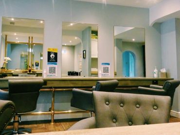 Interior of a modern salon with mirrors and chairs.