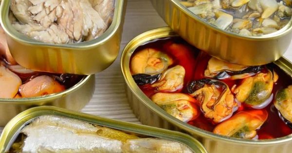 Latas abiertas con diferentes mariscos en conserva.
