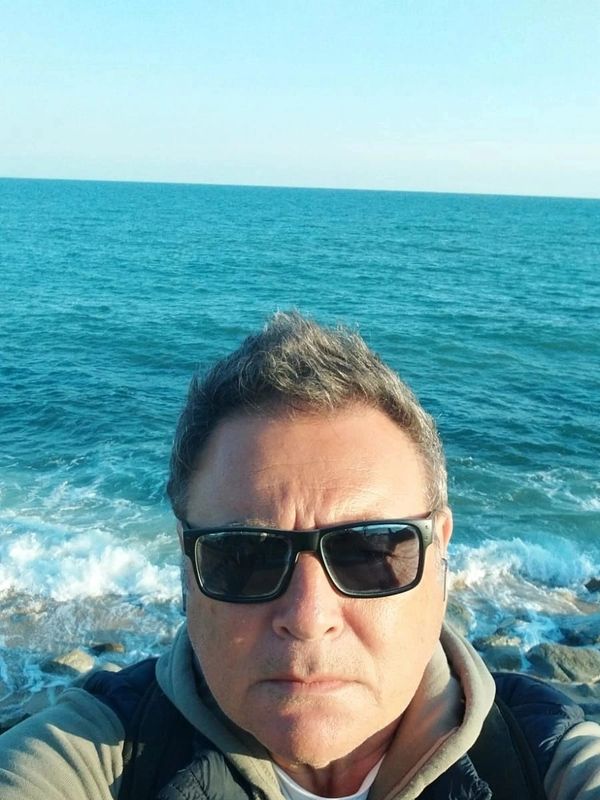 Hombre con gafas de sol en la playa junto al mar.