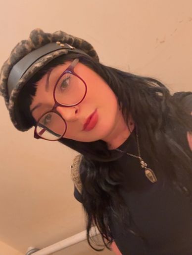Young woman with glasses and leopard print hat.