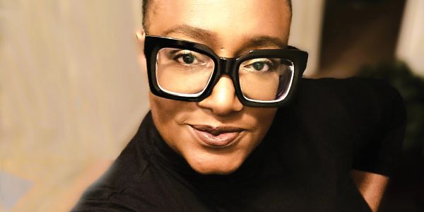Person wearing large black glasses and a black top.