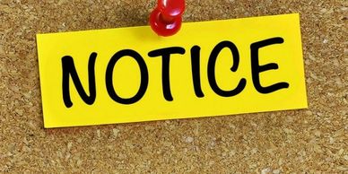 Yellow notice pinned on a corkboard with a red thumbtack.