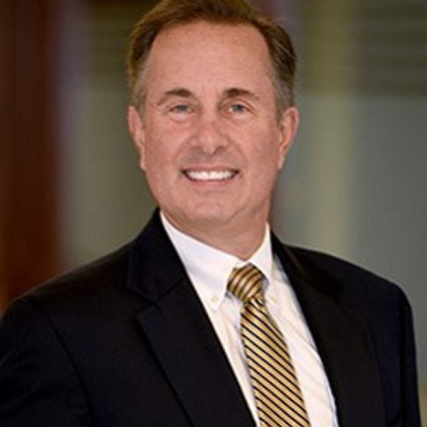 Smiling man in a suit and striped tie.