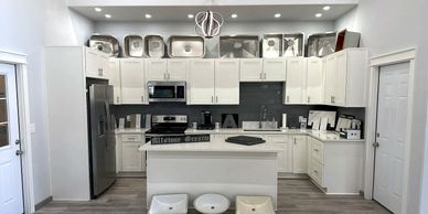 Modern white kitchen with stainless steel appliances and a central island.